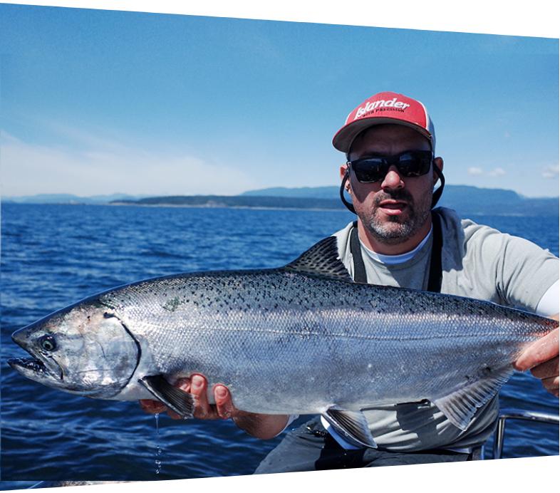 Man in red hat holding large fish caught during fishing tour